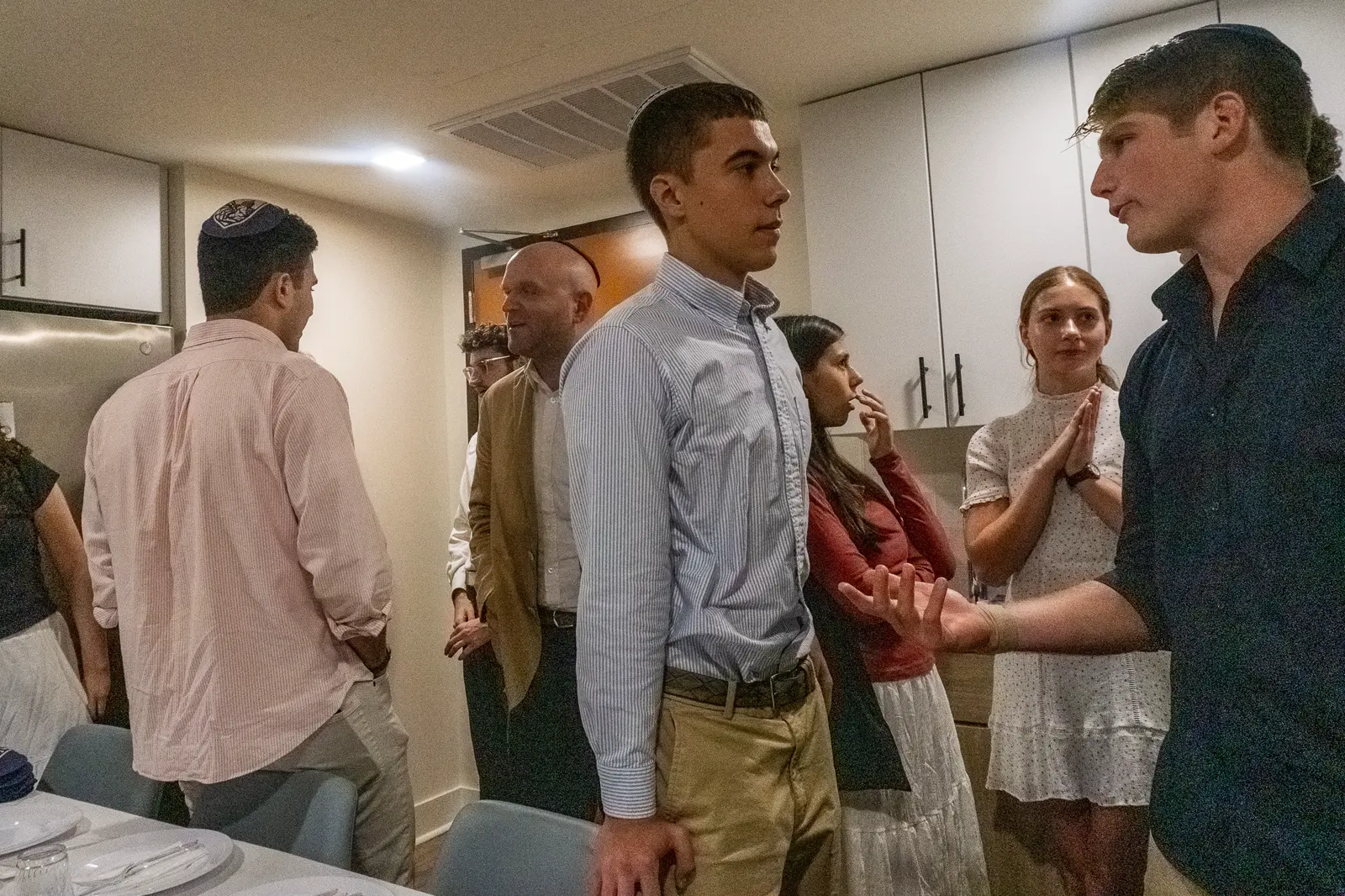 Friends in conversation at a Shabbat dinner
